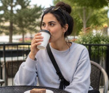 A woman enjoying coffee on a cafe patio in Bolton